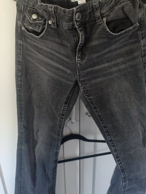 Gråa boot cut jeans - Snygga grå jeans med boot cut. Klassisk femficksmodell med knapp och dragkedja. Jeansen har en tvättad look och är gjorda i mjuk denim som sitter skönt hela dagen.