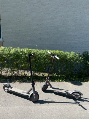 Två grå elsparkcyklar - Säljer två grå elsparkcyklar med svarta och röda detaljer. De har robusta hjul, breda fotplattor och handtag med röd kabeldragning. Perfekt för smidig transport i stan eller till skolan. Laddningsuttag och stöd finns på båda sparkcyklarna. Inga fel på sparkcyklarna och dem funkar precis som de ska, sonen tar körkortet så de var dax att bli av me dom! Bara använda ganska kort stund med inga fel på dem idag. Åker 26 km/h båda två! Pris kan disskuteras, möts upp i Stockholm central.