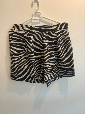 Zebramönstrade shorts i bomull - Snygga shorts med zebramönster i svart och vitt. De har en relaxed fit med resår i midjan och sidofickor. 
