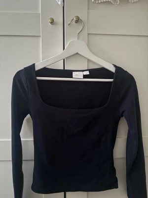 Marinblå långärmad topp med fyrkantig ringning - Säljer en marinblå långärmad topp med snygg fyrkantig ringning i xs ifrån Gina tricot.