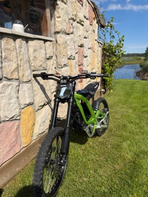 Plate från Alm - Säljer en grön elcykel med robust ram och grova däck, perfekt för terräng och äventyr. Cykeln har svart styre, svart sadel och detaljer i svart och silver. Elmotorn sitter centralt och ramen har en sportig design.