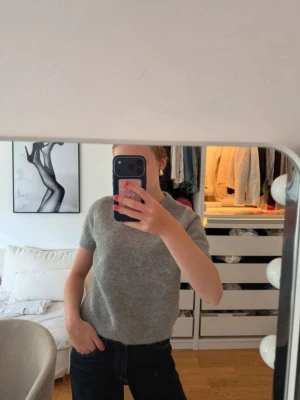 Grå stickad t-shirt från ZARA - Mysig grå stickad t-shirt från ZARA med korta ärmar och rund halsringning. Storlek M men väldigt liten i storlek💗