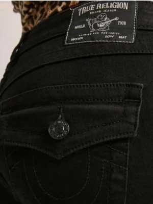 Svarta bootcut-jeans från true religion  - Säljer ett par svarta bootcut-jeans från Wrangler med klassiska fickor och snygga detaljer på bakfickorna. Jeansen har hög midja och är tillverkade i ett stretchigt denimtyg som sitter bekvämt. Perfekta för en trendig och avslappnad look.