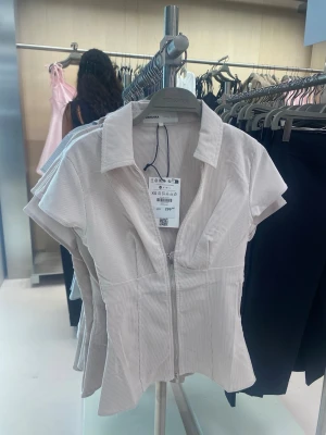 Beige kortärmad blus med dragkedja - Denna blus storlek är mellanS-M!!!!!!! Blusen köptes förra veckan, använd 1 gång.