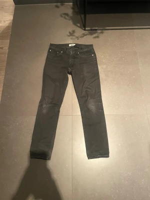 Svarta  jeans från Acne - Säljer ett par svarta skinny jeans från Acne med klassisk femficksdesign och knappgylf. Jeansen har en smal passform och är tillverkade i ett stretchigt denimtyg som sitter snyggt. Perfekta till en avslappnad eller trendig look.