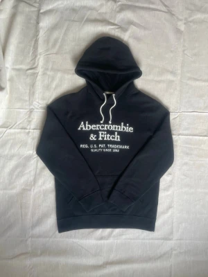 Svart hoodie Abercrombie & Fitch | S - Snygg svart hoodie från Abercrombie & Fitch med vit logga och text på bröstet Skick: Mycket bra | Strl: S | Pris diskuterbart | Hör av dig vid funderingar⁉️ 