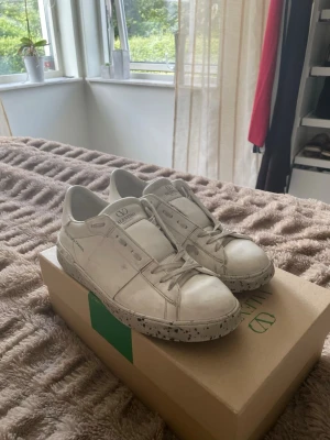 Vita sneakers från Valentino - Säljer nu mina tvär feta valentino garavani open for a change, de är i bra skick men har en liten defekt på inre sidan av skon, inget som syns när man har de på sig! OBS! De är helt äkta men är en limited edition modell som är nästan samma som den vanliga men lite billigare, box, dustbag och äktahetsbevis följer såklart med, vid frågor är det bara att skriva🙌🏼🙌🏼
