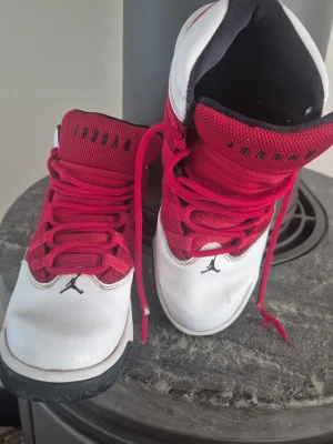Jordan sneakers röd och vit - Fina,bekväma sneakers från Jordan med vit läderöverdel, röda meshpaneler och röda skosnören. Skorna har svart yttersula och svart detalj på plösen där det står 'JORDAN'. Perfekta för dig som gillar streetwear och sportig stil. I bra använd skick