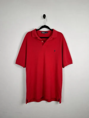 Vintage Polo Ralph Lauren Piké M Röd Classic Relaxed Fit Blue Pony 90s Y2K Herr - • Storlek: M • Färg: Röd  • Passform: Classic Fit  • Krage: Klassisk pikékrage • Material: 100% bomull  Skick: Plagget är i väldigt fint skick. Eventuella anmärkningar anges alltid tydligt i beskrivningen och visas på bilderna.  Nypris: Cirka 1 500 kr.  📦 Skickas snabbt och packas omsorgsfullt. 💬 Hör gärna av dig om du har frågor eller vill se fler bilder. 🤝 Samfrakt erbjuds vid köp av flera plagg – kika gärna in mina andra annonser!