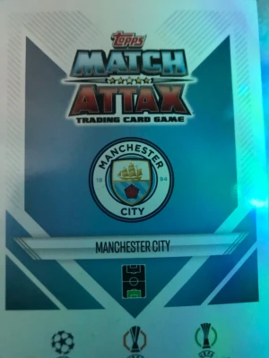 Match Attax fotbollskort Manchester City - Två Match Attax samlarkort från Topps med Manchester City-tema. Ett kort visar klubbens logga och det andra föreställer målvakten Ederson i matchställ. Perfekt för dig som gillar fotboll och samlar på trading cards.