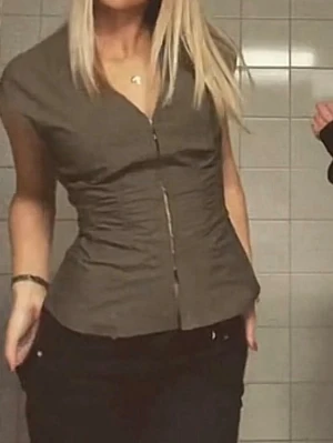 V-ringad blus  - Snygg khakigrön blus med v-ringning. Modellen är figurnära med korta ärmar och markerad midja. 