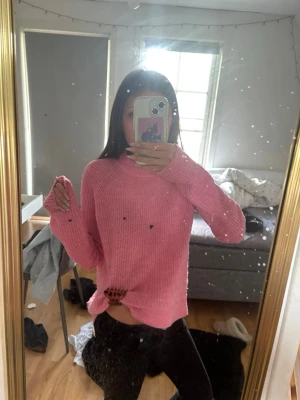 Rosa  stickad tröja - Mysig rosa stickad tröja med oversized passform och långa ärmar. Tröjan har ribbade muddar vid hals. Perfekt för lager på lager och ger en avslappnad look. Materialet ser ut att vara mjukt och fluffigt.