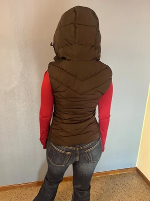 Zara väst med huva - Fin svart väst från Zara med huva, dragkedja och fickor. Perfekt till vår och höst.