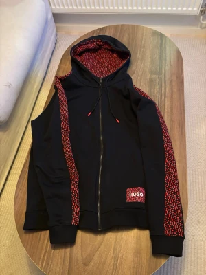 Svart hoodie från HUGO med röda detaljer - Storlek M, jätte fint skick utan några skavanker, använd fåtal gånger