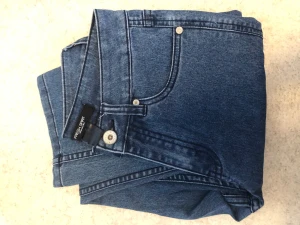 Blå jeans från Fresh Spirit - Snygga blå jeans från Fresh Spirit i klassisk rak eller skinny modell. Jeansen har fem fickor, silverfärgade knappar och är gjorda i ett slitstarkt denimtyg. Perfekta för en avslappnad och trendig look. Vet inte storleken men skulle gissa på xxs eller xs.