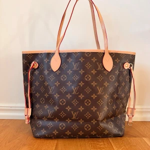 Brun, fin, klassisk och trendig handväska  Monogram väska - Säljer en klassisk brun handväska i brunt monogrammönster som är både trendig och klassisk med fina detaljer. Väskan har snyggt foder och kommer med en matchande liten clutch. Väskan är i nyskick och håller i lång tid framöver på grund av det klassiska utseendet. 