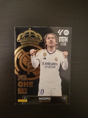 Panini Modric Special One Black kort - Samlarbild från Panini med Luka Modric i Real Madrid, Special One Black edition. Kortet är one-in-30 har svart och guld design med klubbens logga och Modric i matchställ. Baksidan visar nummer 10 och Hall of Fame-text. Perfekt för fotbollssamlare.