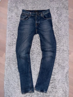 Mörkblå Nudie Jeans - Nudie jeans med feta fades i modell Grim Tim och storlek W29 L32. 