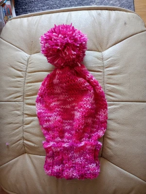 Rosa stickad mössa med tofs stl S/M - Säljer en stickad mössa i olika nyanser av rosa och vitt. Mössan har en stor, fluffig tofs på toppen och bred ribbad kant nedtill. Perfekt för dig som vill ha en färgglad accessoar till vintern. Materialet är mjukt och varmt garn. Ull, polyester, bomull. Tvättråd 40 grader.
