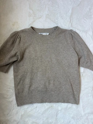 Beige stickad tröja från ONLY - Beige stickad tröja med puffärm från ONLY i strl xs, aldrig använd och har inget tecken på användning. 