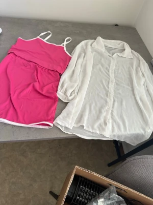 Rosa baddräkt med vita detaljer - Snygg rosa baddräkt med tunna axelband och vita kanter. Enkel och sportig design som passar perfekt för stranden eller poolen. Tillverkad i ett stretchigt material som ger bra komfort och rörelsefrihet.