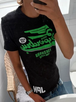 Superdry T-Shirt ~ Vintage - Vintage Superdry T-Shirt | Storlek: S | Passform: Normal/Slim Fit | Färg: Mörkgrå/Grön | Skick: 8/10  Inga Defekter | Pris ej hugget i sten!