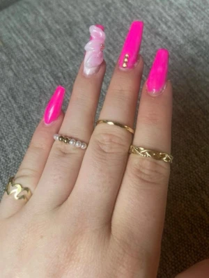 Set med guldiga ringar och pärldetalj - Säljer ett set med fem tunna ringar i guldfärg. En av ringarna har små vita pärlor runt hela ringen, medan de andra har olika släta eller mönstrade designer. Perfekt för dig som gillar att mixa och matcha flera ringar på samma hand.