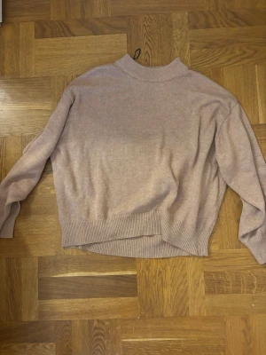 Rosa stickad tröja från H&M - Mysig rosa-beige stickad tröja från H&M med rund halsringning och ribbade muddar vid ärmslut och nederkant. Perfekt för lager på lager och enkel att matcha till olika outfits. Lite för stor på mig men skulle kunna passa andra jättefint!