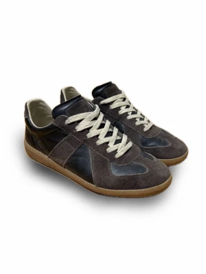 Maison Margiela GATs - Riktigt vackra Maison Margiela GATs med svart full-grain koläder och brun mocka. Insidans skinn består av full-grain fårskinn, vilket garanterar långvarig kvalitet. Storlek 44, sitter TTS!  Är inte första ägare (köpta på vinted) Men har skolåda som innehåller någon form av dammskydd. Hör av er vid frågor, priset är inte hugget i sten!😊Möts upp i stockholm vid eventuella byten.