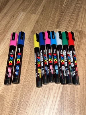 Färgglada Posca pennor 9-pack - Säljer ett set med 9 Posca pennor i olika färger som : rosa, blå, gul, svart, ljusblå, röd, grön och vit. Finns 7 stycken med 3mm spets och 2 med 5mm spets. Pennorna har rund spets och är perfekta för kreativt skapande på material. Styckpris 50 kronor