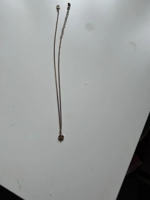 Guldfärgat halsband med fyrklöver - Snyggt guldfärgat halsband med en liten fyrklöverberlock. Kedjan är tunn och har ett justerbart lås. Perfekt för dig som gillar enkla men fina detaljer i din stil.