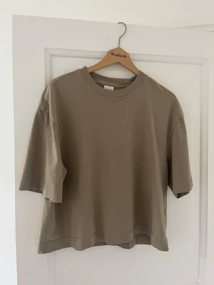 Beige oversized t-shirt Gina Tricot - Säljer en beige oversized t-shirt från Gina Tricot, elevated basics-kollektionen. T-shirten har rund halsringning och korta ärmar. Tillverkad i mjuk bomull för en skön och avslappnad look.