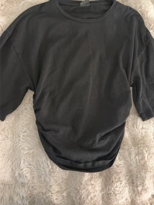 Svart oversized t-shirt - En enkel svart T-shirt som är lös vid bröst och tajt vid magen 