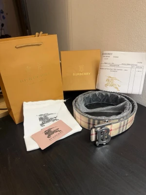 Burberry bälte – 105–110 cm – helt nytt - Säljer ett helt nytt och oanvänt bälte i klassiskt Burberry-mönster med det ikoniska B-spännet i silverfärg. Ett stilrent och lättmatchat bälte som passar både till vardags och när man vill klä upp sig lite extra.  📏 Längd: ca 105–110 cm ✨ Skick: Helt nytt, aldrig använt 🎁 Anledning till försäljning: Fick det i julklapp men kommer inte till användning 📦 Tillbehör: Förpackning, dustbag och tags medföljer ⭐ Kvalitet: Väldigt fin kvalitet och välgjorda detaljer