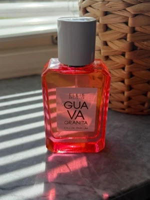 Ellis Brooklyn Guava Granita parfym - Fräsch parfym från Ellis Brooklyn med doften Guava Granita. Flaskan är rektangulär med rosa-orange tonat glas och har en stilren grå kork. Modern design som sticker ut på parfymhyllan. Perfekt för dig som gillar fruktiga och somriga dofter. Ny