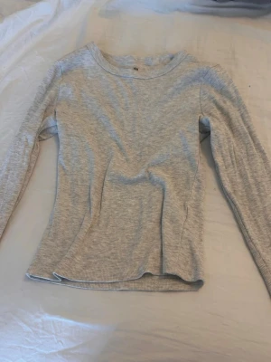 Ljusgrå ribbad långärmad tröja H&M - Söt, basic går tröja perfekt att matcha med ett par jeans inför hösten sitter fint mot kroppen och är i bra skick🩶