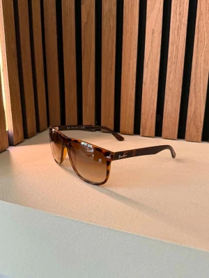 Bruna Ray-Ban boyfriend - Snygga solglasögon från Ray-Ban med brunmelerad båge och bruna tonade glas. Klassisk och tidlös modell som passar perfekt till sommaren. Ray-Ban-loggan syns på sidan och i hörnet av glaset. Riktigt stilrena och lätta att matcha.