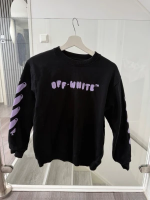 Svart Off-White sweatshirt barn - Svart sweatshirt från Off-White med lila tryck på bröstet. Storlek 152, 12 år. 