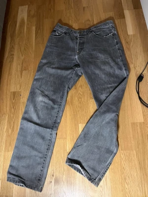 Grå raka jeans från D&G - Säljer ett par grå jeans från D&G med rak passform och klassisk femficksdesign. Jeansen har en diskret tvättad look och är tillverkade i denim. Perfekta för dig som gillar en avslappnad och stilren vibe. Sälsynt modell går knappt att hitta! 