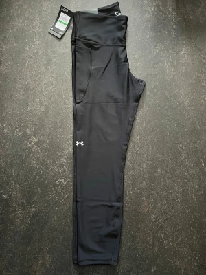 Svarta leggings från Under Armour (Large) - Svarta ankle leggings från Under Armour med hög midja och kompressionseffekt.  Stl L                   Helt ny Nypris (599)