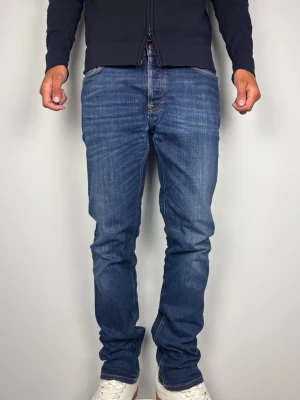 Nudie Jeans Co Dude Dan W33 L34 - Blåa Jeans Denim - Snygga Nudie Jeans i modellen Dude Dan med Dark Deep Worn tvätt. Mycket fint skick,  A-B Grade  Storlek W33 L34 i 99% bomull & 1% elastan.  Mått [platt] :  A: 43 cm B: 113 cm C: 27 cm D: 20 cm Passar bra på mig i bilden som är 189 cm lång men passar även längre. Skickas snabbt!