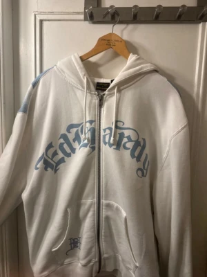 UO Ecru Tiger Hoodie Av Ed Hardy - En hoodie från Urban outfitters. Hoodien är köpt på nätet av UO och är använd men färgen på baksidan har spretat ut sig lite pga fel tvättning men är annars i bra skick.
