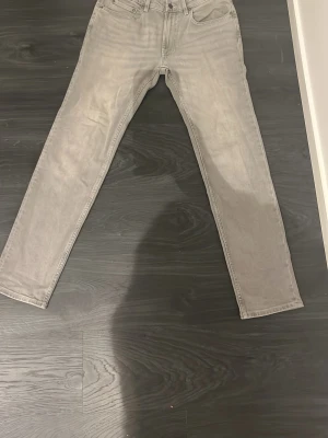 Gråa jeans - Säljer nu dessa gråa jeans ifrån dressman. Det är i nytt skick då de bara har använts 1 gång. De är i regular passform så dom sitter lite bredare vid smalbenen, De är i storlek 30/32                                                             Hör av er vid minsta lilla fundering🙌