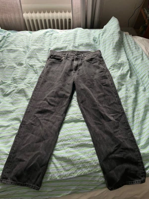 Grå loose fit jeans Weekday - Säljer ett par gråa loose fit jeans från Weekday i modellen Galaxy Loose Straight. Jeansen har raka ben, klassisk femficksdesign och är tillverkade i denim. Perfekta för en avslappnad och trendig look.