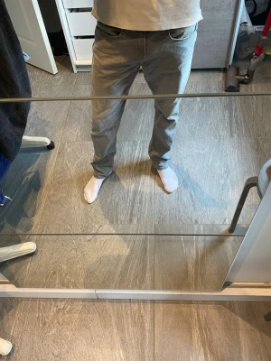 Ljusgrå raka jeans - Säljer ett par ljusgrå jeans med rak passform och klassisk femficksdesign. Jeansen har normal midja och är tillverkade i ett mjukt denimtyg som ger en avslappnad look. Perfekta för dig som gillar stilrena och enkla jeans.