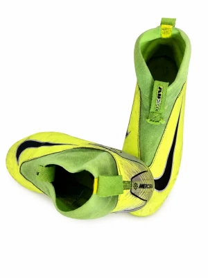 Nike Mercurial gula fotbollsskor - Snygga fotbollsskor från Nike Mercurial-serien i neon-gult med svarta detaljer och vit sidopanel. Skorna har en strömlinjeformad design, högre ankel och dragflik baktill. Materialet är syntetiskt och skon har dobbar för spel på gräs.