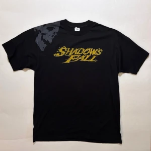 Shadows Fall Skull T-shirt - Band-tee från bandet Shadows Fall, på trycket står det 2006  Nyskick. Necktags är knyckliga för tröjan legat ihopvikt i ett tag. Rätar ut sig vid tvätt.  100% bomull  Skicka ett meddelande om du har frågor eller vill se fler bilder