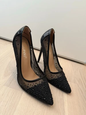 Svarta pumps med mesh och strass - Snygga svarta pumps från Tulipano likt Louboutins. Aldrig använda 