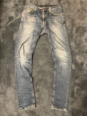Ljusblå nudie jeans - Skick: 8/10 | Nudie Jeans. Storlek: W29 L32  ett par riktigt fina nudie jeans med slim passform som sitter riktigt fint på kroppen, lappade och lagade av nudie, som med alla nudie jeans så finns det en livstids lagnings garanti hos nudie själva om frågor finns var inte rädd för att skjuta ett meddelande 