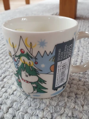 Muminmugg Under granen Mumin  - Felfri mugg med etikett kvar. Säljer fler Muminmuggar så kika gärna på mina övriga annonser också. Packar mycket noggrant. 